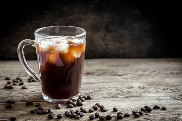 Buzlu kahve ve kahve çekirdekleri rustik ahşap masa, kopya alanı üzerinde. Yenileme buzlu kahve.
