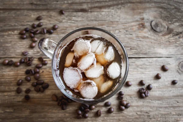 Buzlu kahve ve kahve çekirdekleri rustik ahşap masa, kopya alanı üzerinde. Yenileme buzlu kahve.