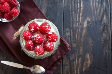 Ahududu cheesecake tatlı taze ahududu ve ahşap zemin üzerine krem peynir ile cam kavanoza. Sağlıklı ev yapımı yaz katmanlı berry tatlı.