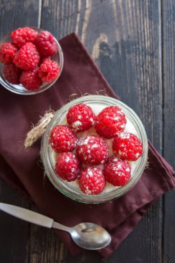 Ahududu cheesecake tatlı taze ahududu ve ahşap zemin üzerine krem peynir ile cam kavanoza. Sağlıklı ev yapımı yaz katmanlı berry tatlı.