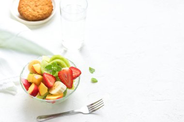 Sağlıklı kahvaltı veya aperatif için kase meyve salatası. Ham vejetaryen fitness gıda ve yaşam tarzı kavramı, beyaz arka plan kopya alanı ile diyet.