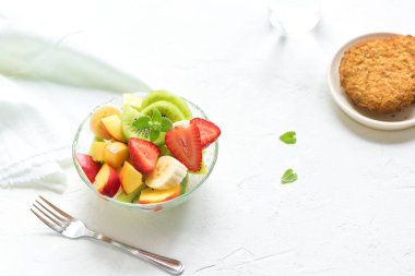 Sağlıklı kahvaltı veya aperatif için kase meyve salatası. Ham vejetaryen fitness gıda ve yaşam tarzı kavramı, beyaz arka plan kopya alanı ile diyet.