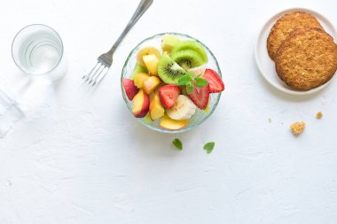 Sağlıklı kahvaltı veya aperatif için kase meyve salatası. Ham vejetaryen fitness gıda ve yaşam tarzı kavramı, beyaz arka plan kopya alanı ile diyet.