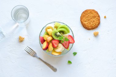 Sağlıklı kahvaltı veya aperatif için kase meyve salatası. Ham vejetaryen fitness gıda ve yaşam tarzı kavramı, beyaz arka plan kopya alanı ile diyet.