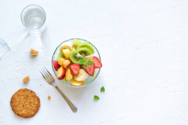 Sağlıklı kahvaltı veya aperatif için kase meyve salatası. Ham vejetaryen fitness gıda ve yaşam tarzı kavramı, beyaz arka plan kopya alanı ile diyet.