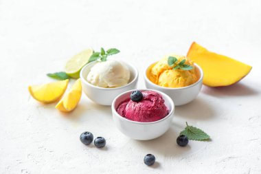 Üç çeşitli meyve ve çilek dondurma beyaz arka planda, kopya alanı. Dondurulmuş yoğurt veya dondurma ile limon, mango, yaban mersini - sağlıklı yaz tatlı.