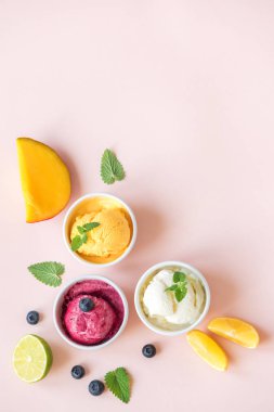 Üç çeşitli meyve ve çilek dondurma pembe arka plan, kopya alanı üzerinde. Dondurulmuş yoğurt veya dondurma ile limon, mango, yaban mersini - sağlıklı yaz tatlı.
