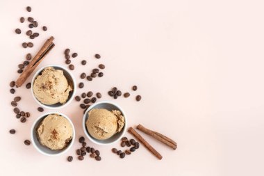 Kahveli dondurma pembe pastel arka planda, üstten görünüm alanı kopyalayın. Kahve çekirdekleri ile dondurulmuş kahve gelato dondurma ve tarçın - sağlıklı tatlı yaz.