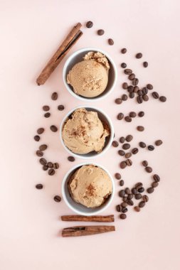 Pastel pembe, üstten görünüm üzerinde kahveli dondurma. Kahve çekirdekleri ile dondurulmuş kahve gelato dondurma ve tarçın - sağlıklı tatlı yaz.