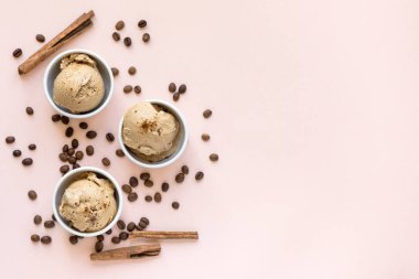 Pastel pembe, üstten görünüm üzerinde kahveli dondurma. Kahve çekirdekleri ile dondurulmuş kahve gelato dondurma ve tarçın - sağlıklı tatlı yaz.