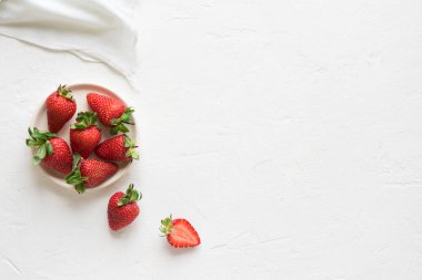 Kopya alanı, beyaz beton zemin üzerine plaka üzerinde taze organik çilek görünümü top.
