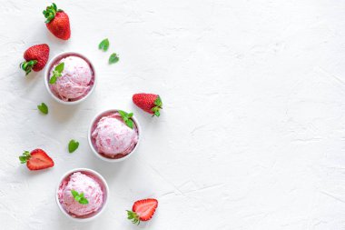 Çilekli dondurma ve beyaz arka planda, üstten görünüm taze çilek. Üç kâse çilekli dondurma, sağlıklı tatlı yaz.