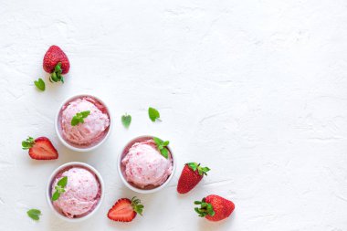 Çilekli dondurma ve beyaz arka planda, üstten görünüm taze çilek. Üç kâse çilekli dondurma, sağlıklı tatlı yaz.