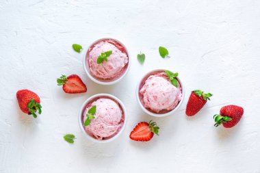 Çilekli dondurma ve beyaz arka planda, üstten görünüm taze çilek. Üç kâse çilekli dondurma, sağlıklı tatlı yaz.