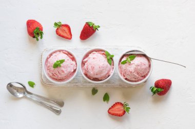 Çilekli dondurma ve beyaz arka planda, üstten görünüm taze çilek. Üç kâse çilekli dondurma, sağlıklı tatlı yaz.