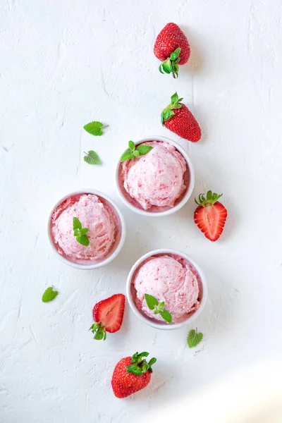 Çilekli dondurma ve beyaz arka planda, üstten görünüm taze çilek. Üç kâse çilekli dondurma, sağlıklı tatlı yaz.