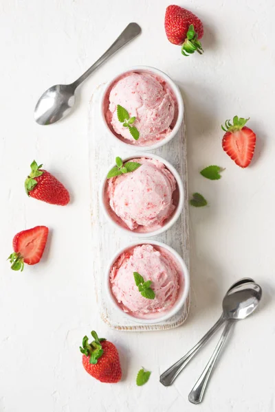 Çilekli dondurma ve beyaz arka planda, üstten görünüm taze çilek. Üç kâse çilekli dondurma, sağlıklı tatlı yaz.