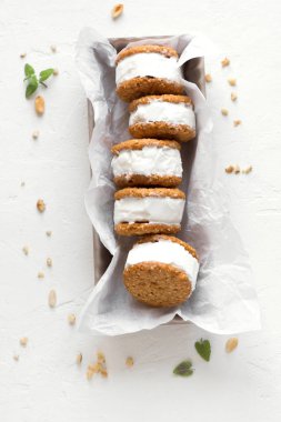 Dondurma sandviç ile fındık ve kepekli kurabiye. Beyaz zemin üzerine ev yapımı vanilyalı dondurma sandviç.