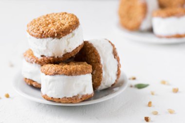 Dondurma sandviç ile fındık ve kepekli kurabiye. Beyaz zemin üzerine ev yapımı vanilyalı dondurma sandviç.