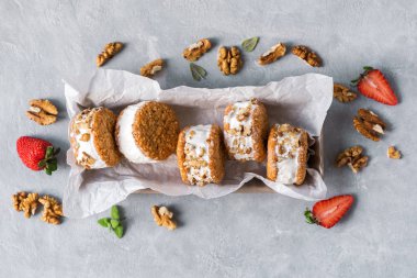 Dondurma sandviç ile fındık ve kepekli kurabiye. Ev yapımı vanilyalı dondurma sandviç gri beton zemin üzerine.