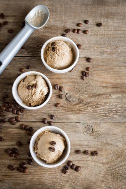 Ahşap arka plan, üstten görünüm üzerinde kahveli dondurma. Kahve çekirdekleri ile dondurulmuş kahve gelato dondurma ve tarçın - sağlıklı tatlı yaz.