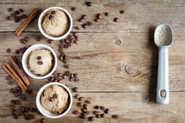 Ahşap arka plan, üstten görünüm üzerinde kahveli dondurma. Kahve çekirdekleri ile dondurulmuş kahve gelato dondurma ve tarçın - sağlıklı tatlı yaz.