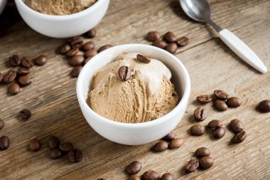 Coffee ice cream on wooden background. Homemade coffee gelato ice cream with coffee beans - healthy summer vegan dessert. clipart