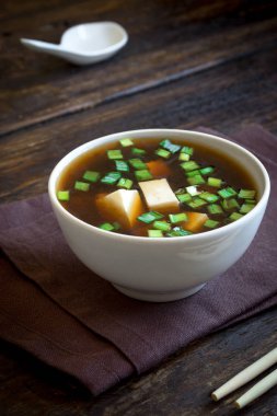 Japon miso çorbası koyu ahşap arka plan, kopya alanı üzerinde seramik kase. Asya miso çorbası ile tofu.