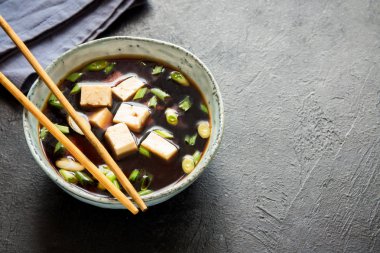 Japon miso çorbası kopya alanı siyah taş masada seramik kase. Asya miso çorbası ile tofu.