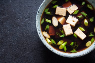 Japon miso çorbası kopya alanı siyah taş masada seramik kase. Asya miso çorbası ile tofu.