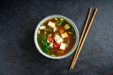 Japon miso çorbası kopya alanı siyah taş masada seramik kase. Asya miso çorbası ile tofu.