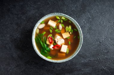 Japon miso çorbası kopya alanı siyah taş masada seramik kase. Asya miso çorbası ile tofu.