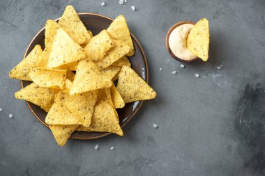 Cips cips ve eritilmiş peynir. Tortilla Mısır Meksika cips cips kase ve peynir sos daldırma gri taş zemin, kopya alanı üzerine.