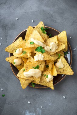 Cips cips ve eritilmiş peynir. Tortilla Mısır Meksika cips cips kase ve peynir sos daldırma gri taş zemin, kopya alanı üzerine.