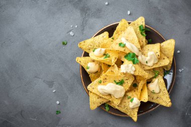 Cips cips ve eritilmiş peynir. Tortilla Mısır Meksika cips cips kase ve peynir sos daldırma gri taş zemin, kopya alanı üzerine.