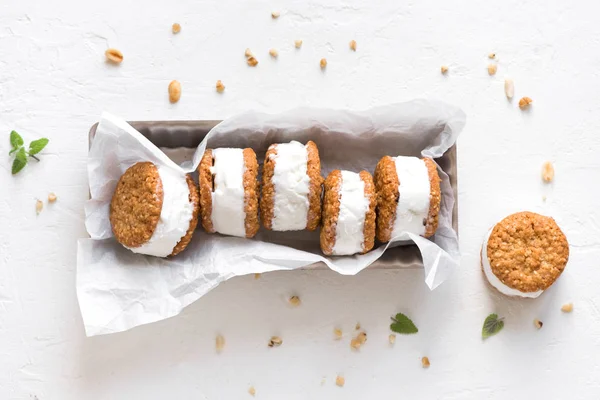 Dondurma sandviç ile fındık ve kepekli kurabiye. Beyaz zemin üzerine ev yapımı vanilyalı dondurma sandviç.