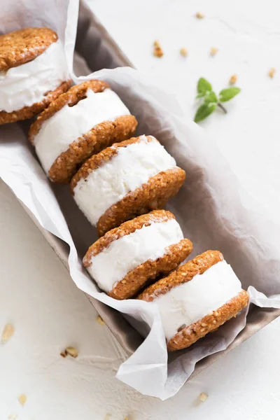 Dondurma sandviç ile fındık ve kepekli kurabiye. Beyaz zemin üzerine ev yapımı vanilyalı dondurma sandviç.