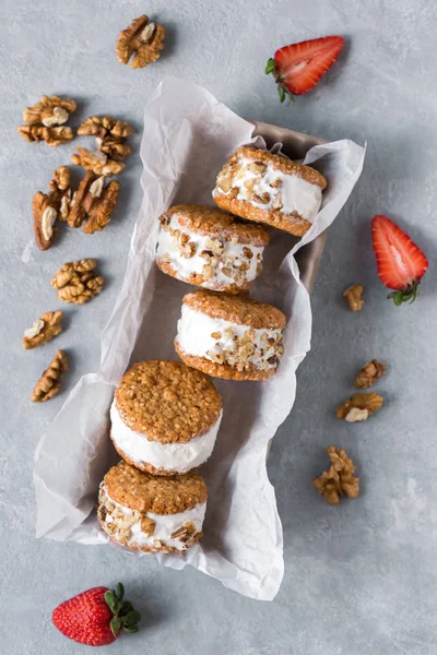 Dondurma sandviç ile fındık ve kepekli kurabiye. Ev yapımı vanilyalı dondurma sandviç gri beton zemin üzerine.