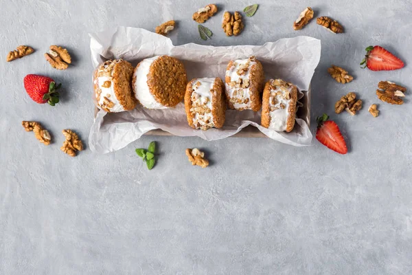 Dondurma sandviç ile fındık ve kepekli kurabiye. Ev yapımı vanilyalı dondurma sandviç gri beton zemin üzerine.