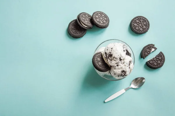 Ice cream with chocolate and cream sandwich cookies. Cookies and cream homemade ice cream dessert on blue background, copy space.