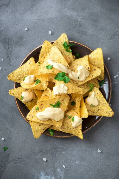 Cips cips ve eritilmiş peynir. Tortilla Mısır Meksika cips cips kase ve peynir sos daldırma gri taş zemin, kopya alanı üzerine.