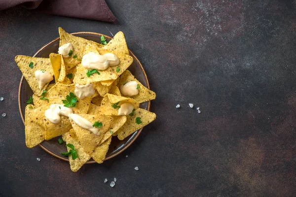 Cips cips ve peynir sosu koyu arka plan, kopya alanı üzerinde daldırma. Tortilla Mısır cips cips eritilmiş peynir, Meksika aperatifler.