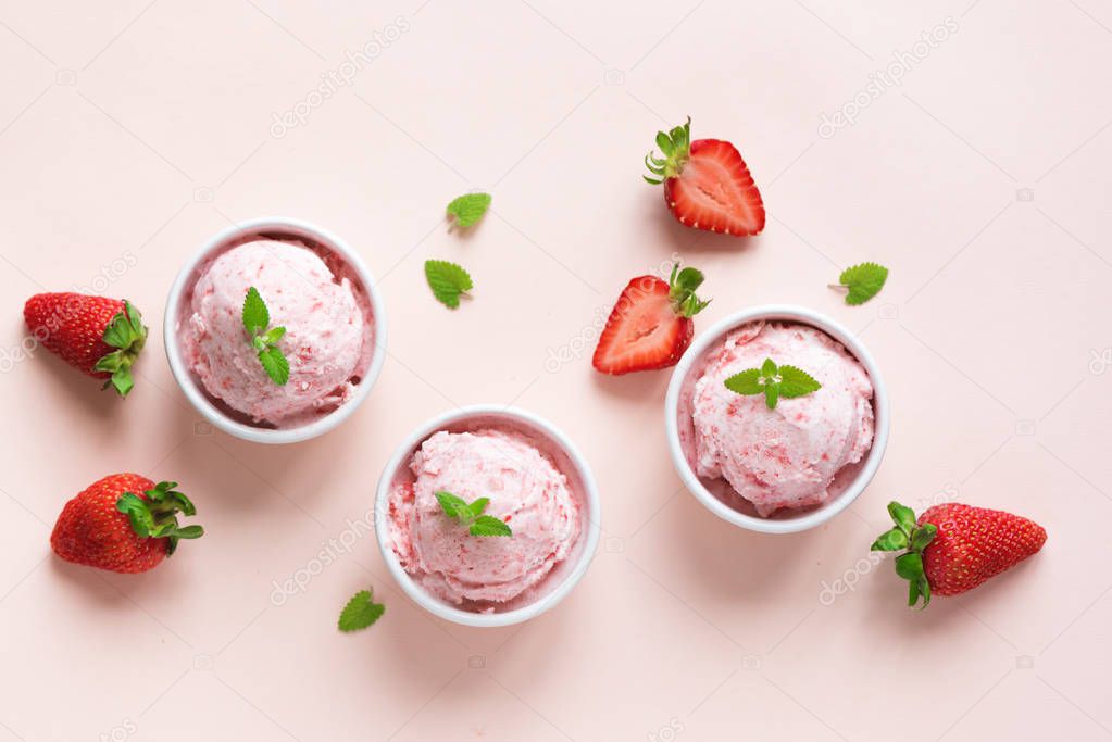 Strawberry ice cream and fresh strawberries flat lay on pink pastel background. Three bowls of strawberry ice cream, healthy summer dessert.