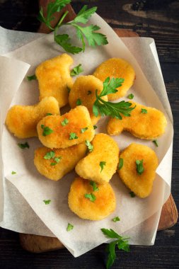 Tavuk kanadı kadar koyu ahşap backgroundclose. Fried nuggets maydanoz ile.