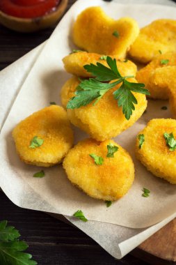 Tavuk nuggets ve koyu ahşap zemin, kopya alanı üzerine sos. Fried nuggets ketçap ve mayonez ile.