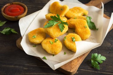 Tavuk nuggets ve koyu ahşap zemin, kopya alanı üzerine sos. Fried nuggets ketçap ve mayonez ile.