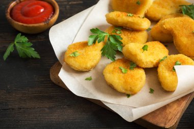 Tavuk nuggets ve koyu ahşap zemin, kopya alanı üzerine sos. Fried nuggets ketçap ve mayonez ile.