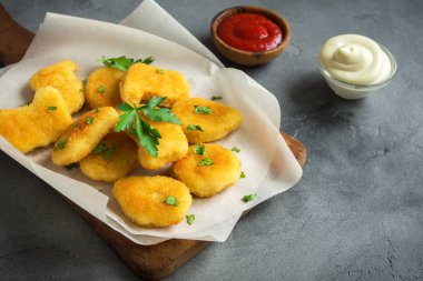 Tavuklu ve gri beton arka planda, kopya alanı sos. Kızarmış tavuk brest nuggets ketçap ve mayonez ile.