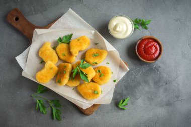 Tavuklu ve gri beton arka planda, kopya alanı sos. Kızarmış tavuk brest nuggets ketçap ve mayonez ile.