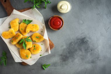Tavuklu ve gri beton arka planda, kopya alanı sos. Kızarmış tavuk brest nuggets ketçap ve mayonez ile.
